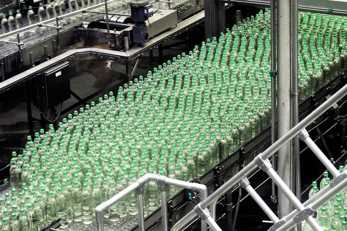 Hundreds of capped bottles massed on the outfeed of a bottling plant